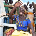 Woman using the new well in Layik A village in Iganga, Uganda