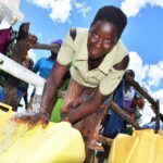 Woman using the new borehole well in Layik A village in Iganga, Uganda