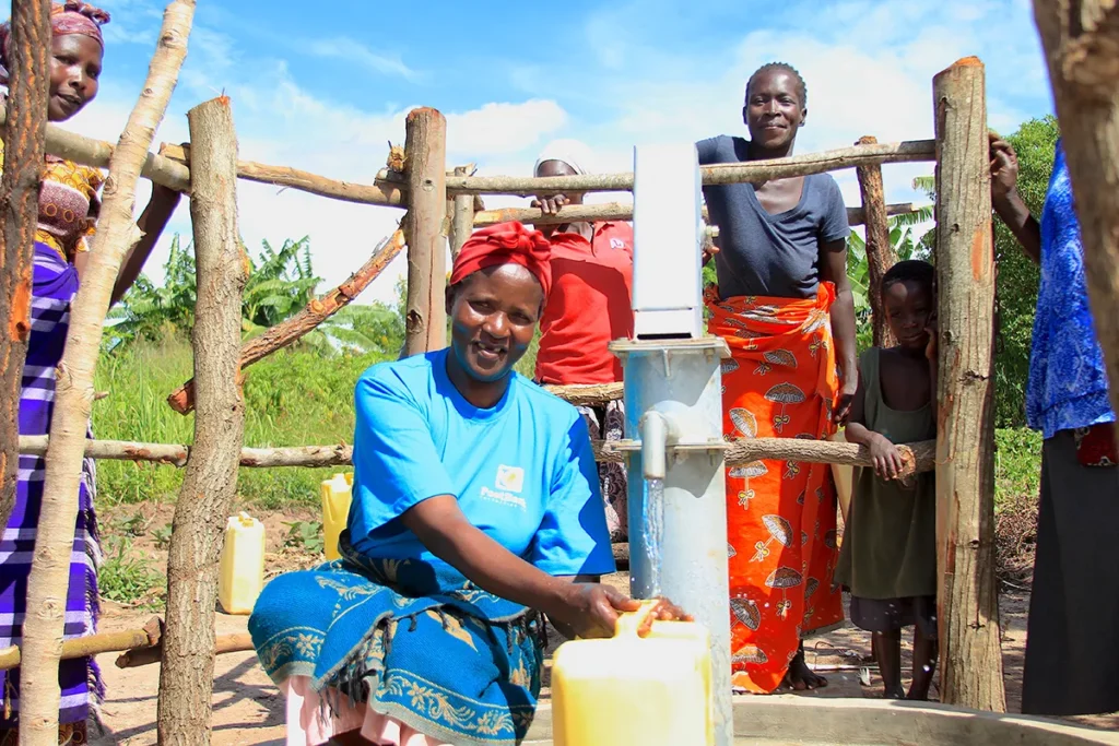A woman from the Oduku Go-Down village in Nwoya, Uganda gets clean water from the new borehole drilled by US water charity Drop in the Bucket