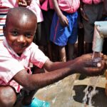 Young boy from the Kabuli primary school in Iganga Uganda getting clean water from the newly drilled borehole