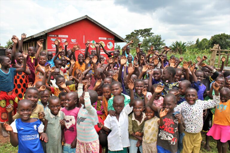 Mwendanfuku-Iganga_Uganda water wells-01 - Drop In the Bucket Children from the Mwendanfuku primary school in Iganga, Uganda standing by the new well drilled by Drop in the Bucket in 2022