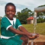 A girl gets clean water from the new well drilled by Drop in the Bucket for the St. Kiziti Good Foundation nursery and primary school in Inanga, Uganda
