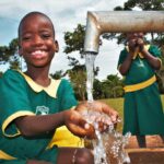 A girl gets clean water from the new well drilled by Drop in the Bucket for the St. Kiziti Good Foundation nursery and primary school in Inanga, Uganda
