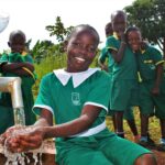 A girl gets clean water from the new well drilled by Drop in the Bucket for the St. Kiziti Good Foundation nursery and primary school in Inanga, Uganda