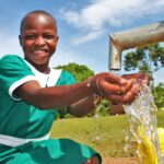 A girl gets clean water from the new well drilled by Drop in the Bucket for the St. Kiziti Good Foundation nursery and primary school in Inanga, Uganda