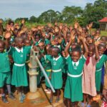 pupils from the St. Kiziti Good Foundation nursery and primary school in Inanga, Uganda celebrating the new well drilled by Drop in the Bucket