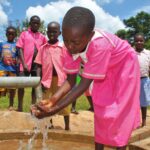 A girl gets clean water from the new well drilled by Drop in the Bucket for the St. Joseph's primary school in Iganga, Uganda