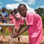 A girl gets clean water from the new well drilled by Drop in the Bucket for the St. Joseph's primary school in Iganga, Uganda