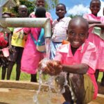 A student gets clean water from the new well drilled by Drop in the Bucket for the St. Joseph's primary school in Iganga, Uganda