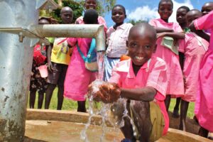 A student gets clean water from the new well drilled by Drop in the Bucket for the St. Joseph's primary school in Iganga, Uganda