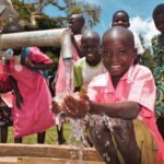 A student gets clean water from the new well drilled by Drop in the Bucket for the St. Joseph's primary school in Iganga, Uganda