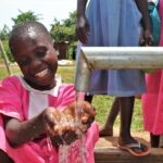 A girl gets clean water from the new well drilled by Drop in the Bucket for the St. Joseph's primary school in Iganga, Uganda