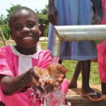 A girl gets clean water from the new well drilled by Drop in the Bucket for the St. Joseph's primary school in Iganga, Uganda