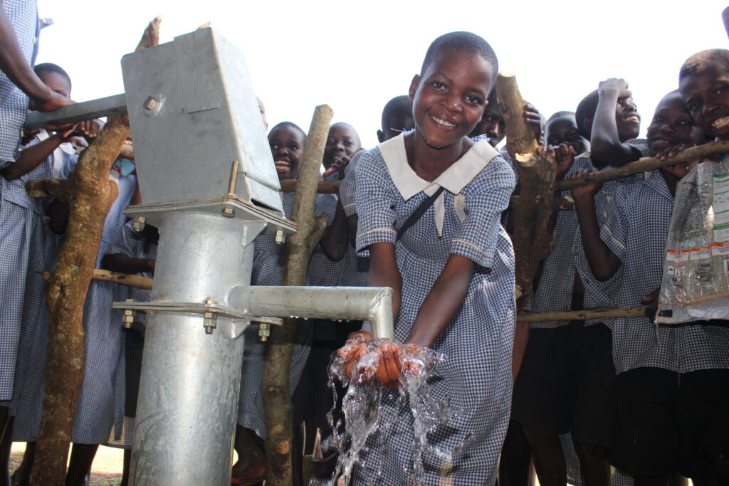 A female student gets clean water from the new borehole at the Nawangisa Church of Uganda primary school in Gulu, Uganda