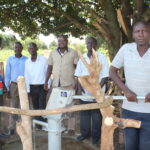 Members of the local community stand by the new well at the Nawangisa COU primary school in Iganga, Uganda