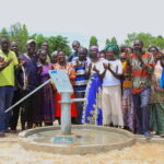 The local community in Latengelere village in Nwoya, Uganda gathers around the newly drilled borehole
