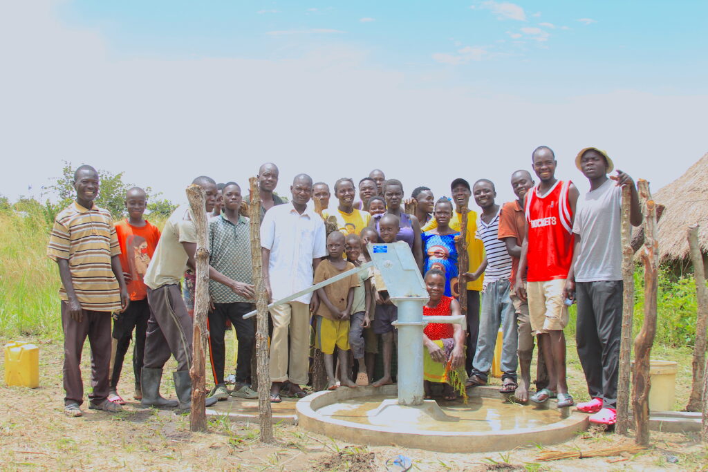 Community members gather around the well in Lamoki, Uganda drilled by US water charity Drop in the Bucket