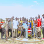 Community members gather around the well in Lamoki, Uganda drilled by US water charity Drop in the Bucket