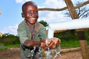 A boy from Aworanga village in Omoro, Uganda gets clean water from the new well drilled by Drop in the Bucket