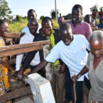 Community members from Nyapeya village in Uganda get safe water from the new well drilled by Drop in the Bucket