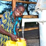 A woman from kalongak village in Gulu, Uganda gets clean water from the new well drilled by Drop in the Bucket