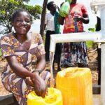Community members from Patiri village in Nwoya, Uganda using the new well drilled by Drop in the Bucket