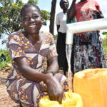 Community members from Patiri village in Nwoya, Uganda using the new well drilled by Drop in the Bucket