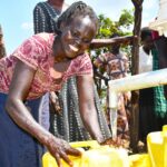 A woman from Patiri village in Nwoya, Uganda using the new well drilled by Drop in the Bucket