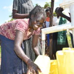 Community members from Patiri village in Nwoya, Uganda using the new well drilled by Drop in the Bucket