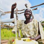 woman collecting clean water at a borehole well in Lakuny, Uganda