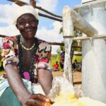 Woman filling a water container at a clean water well in Lakuny, Uganda