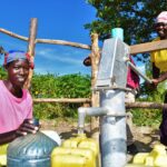 A woman gets clean water from a newly drilled well at the Diving Kingdom church in Omoro, Uganda