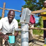A woman gets clean water from a newly drilled well at the Diving Kingdom church in Omoro, Uganda