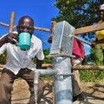 A woman gets clean water from a newly drilled well at the Diving Kingdom church in Omoro, Uganda