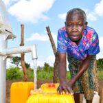 A community stakeholder from Tukupe community in Amuru, Uganda using the new well drilled by Drop in the Bucket