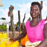 A woman from Tukupe community in Amuru, Uganda gets clean water from the new well drilled by Drop in the Bucket