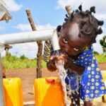 A girl from Tukupe community in Amuru, Uganda gets clean water from the new well drilled by Drop in the Bucket