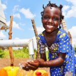 A girl from Tukupe community in Amuru, Uganda gets clean water from the new well drilled by Drop in the Bucket