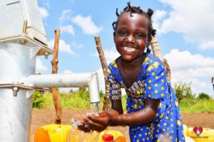 A girl from Tukupe community in Amuru, Uganda gets clean water from the new well drilled by Drop in the Bucket