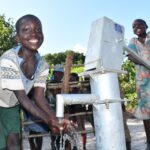 Getting clean water for the first time from the new well at Bidin B village in Nwoya, Uganda