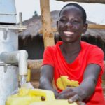 A young boy from duddut village in Omoro, Uganda gets clean water from the new well drilled by Drop in the Bucket