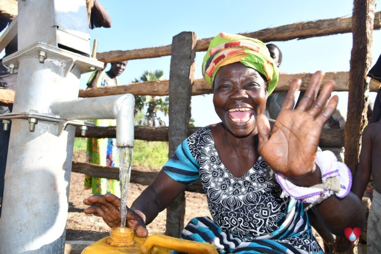 A woman from the Awornyim central community in Gulu, Uganda gets safe water from a new borehole drilled by Drop in the Bucket