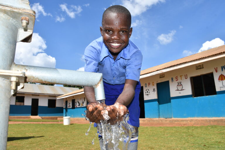 God's Glory Primary School, Gulu, Uganda - Drop In the Bucket A child gets clean, safe water from a newly drilled well at the God's Glory primary school in Gulu, Uganda
