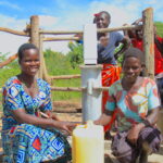 Women collecting water at a clean water well in Oduku village, Nwoya District, Uganda