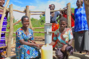 Women collecting water at a clean water well in Oduku village, Nwoya District, Uganda