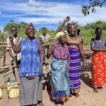 Community members using a clean water well in Oduku village, northern Uganda
