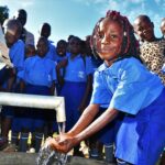 A child gets clean, safe water from a newly drilled well at the God's Glory primary school in Gulu, Uganda