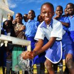 A child gets clean, safe water from a newly drilled well at the God's Glory primary school in Gulu, Uganda