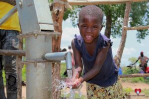 Child getting clean water from the new water well in Opok village in Nwoya, Uganda