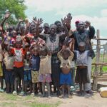 Community members gather around the new water well in Opok village in Nwoya, Uganda